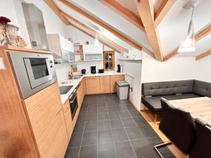 eine Küche mit Holzschränken und einer Arbeitsplatte in der Unterkunft Modern Mountain Penthouse - an der Skipiste in Rauris