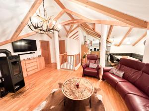 uma sala de estar com um sofá e uma mesa em Modern Mountain Penthouse - an der Skipiste em Rauris