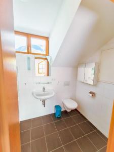 ein Bad mit einem Waschbecken und einem WC in der Unterkunft Modern Mountain Penthouse - an der Skipiste in Rauris