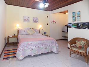 a bedroom with a large bed and a chair at Portal dos Borbas in Abraão