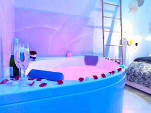 Habitación de juguete con bañera rosa y copa de vino en The Pearl - Jacuzzi SPA - Ecran géant - Parking, en Le Havre