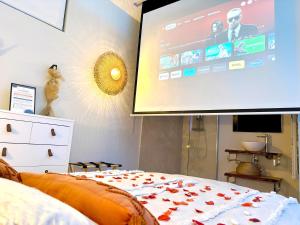1 dormitorio con una gran pantalla en la pared en The Pearl - Jacuzzi SPA - Ecran géant - Parking, en Le Havre