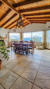 a dining room with a table and chairs and windows at La gringa 1 in San Carlos de Bariloche