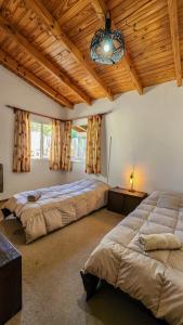 a bedroom with two beds and a chandelier at La gringa 1 in San Carlos de Bariloche