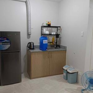 eine Küche mit einer Theke mit einer Spüle und einem Kühlschrank in der Unterkunft Piper Condo at Urban Deca in Mandaue City
