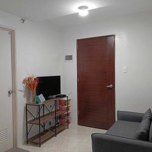 sala de estar con sofá y TV en Piper Condo at Urban Deca en Mandaue City