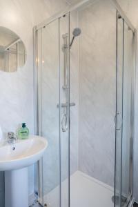 a shower with a glass door next to a sink at Modern - 2 Bed - Free Parking in Coxhoe