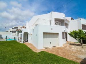 a white house with a garage in a yard at Villa Double Joy by Stay ici in Albufeira