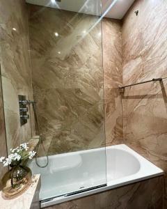 ein Badezimmer mit einer Dusche und einer weißen Badewanne in der Unterkunft Homely One Bedroom Apartment in London