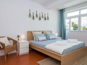 a bedroom with a bed and a chair and a window at Villa Double Joy - Privacy & Privat Pool & Garden & Top Location & Albufeira in Albufeira