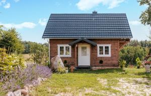 une petite maison en bois avec un toit noir dans l'établissement Beautiful Home In Male Gacno With Kitchen, à Małe Gacno