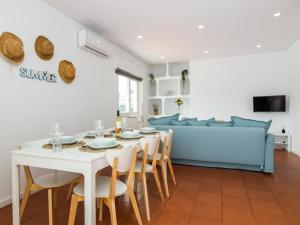 a living room with a table and a blue couch at Villa Double Joy by Stay ici in Albufeira