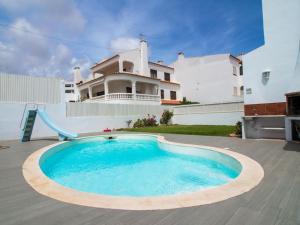 a pool with a slide in front of a house at Villa Double Joy by Stay ici in Albufeira