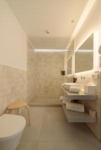 a bathroom with two sinks and a toilet and a tub at Hotel Serawa Alicante in Alicante