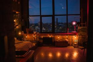 a bedroom with a view of a city at night at Лофт студия с панорамной террасой in Mykolaiv