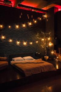 a bedroom with a bed with lights on a brick wall at Лофт студия с панорамной террасой in Mykolaiv