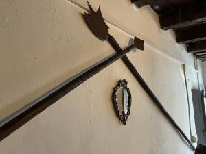 uma faca pendurada numa parede com uma coroa de flores em L'Antico Palazzo - Mansion with pool em Toano