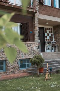 a stone house with a porch with a table and chairs at Kamena kuća in Požega