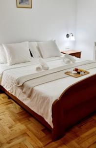 Una gran cama blanca con una bandeja de fruta. en Nadija Rooms Funtana, en Funtana