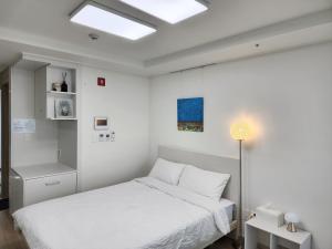 a white bedroom with a bed and a skylight at Sokcho Summitbay 1701 "Ocean View" in Sokcho