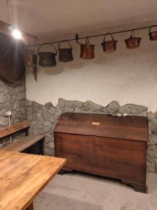 Cette chambre est dotée d'un mur en pierre avec des pots en cuivre sur le mur. dans l'établissement Il posto al sole, à Teglio