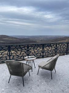 two chairs and a table on a balcony with a view at Wine Valley Villas in Lipovac
