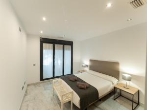 a bedroom with a large bed and two tables and a chair at Apto Valdespino Gran Terraza fjHomefj in Jerez de la Frontera