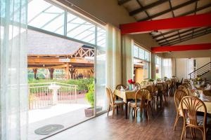 a restaurant with tables and chairs and a large window at Bomah Hotel Limited in Gulu