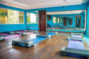 a room with a yoga class with blue walls and mirrors at Bomah Hotel Limited in Gulu