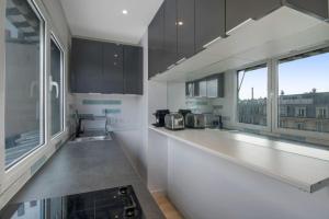een keuken met zwarte kasten en een wit aanrecht bij 1 Bedroom#Haussmann#Amazing view#EffeilTower#AC in Parijs