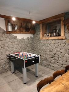 a game table in a room with a stone wall at Il posto al sole in Teglio