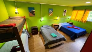 twee bedden in een kamer met groene muren bij OTTO SKY & SUMMER in Bariloche