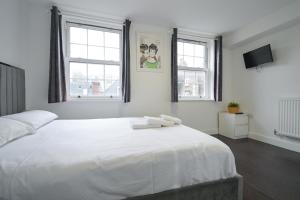 a bedroom with a large white bed with two towels on it at Charlotte Street Rooms by News Hotel in London