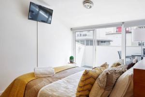 a bedroom with a bed with a tv on the wall at University View Loft in Coimbra