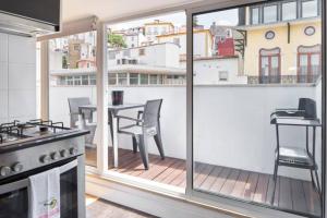 a kitchen with a balcony with a table and chairs at University View Loft in Coimbra