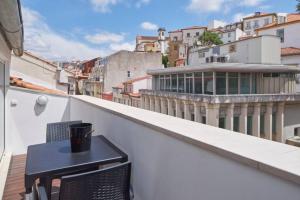 a black table and two chairs on a balcony at University View Loft in Coimbra