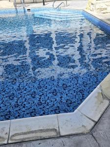 una piscina con agua azul en el medio en Delightful Poolside apartment, en Pafos
