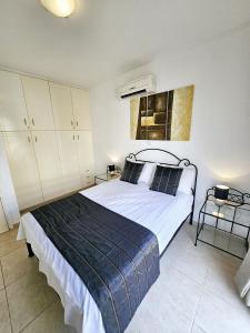 Un dormitorio con una cama con una manta azul. en Delightful Poolside apartment, en Pafos