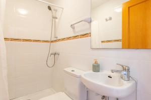 Un baño blanco con lavabo y ducha. en Ferrera Soul 1b, en Santanyí 16 fotos más