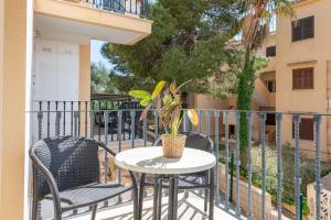 una mesa y sillas en un balcón con una planta en Ferrera Soul 1b, en Santanyí