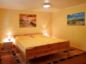 1 dormitorio con 1 cama de madera en una habitación con 2 lámparas en An der Brake, Bungalow, en Prerow