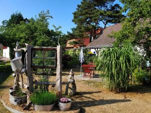 un jardín con una puerta de madera y algunas plantas en An der Brake, Bungalow, en Prerow