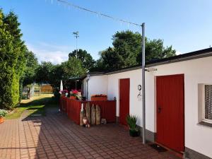 un edificio blanco con puertas rojas y entrada de ladrillo en An der Brake, Bungalow, en Prerow