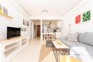 een woonkamer met een bank en een tv bij Apartamento coqueto con terraza junto a Candelaria in Candelaria