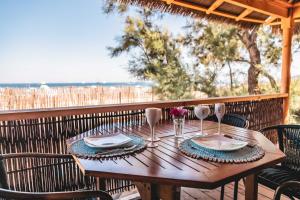 un tavolo in legno con piatti e bicchieri da vino su un patio di Kon Tiki a Saint-Tropez