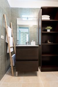 een badkamer met een wastafel en een spiegel bij Apartamento coqueto con terraza junto a Candelaria in Candelaria