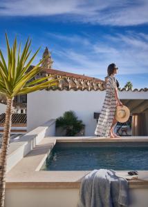 een vrouw die op het dak van een huis naast een zwembad loopt bij Boutique Hotel Posada Terra Santa in Palma de Mallorca