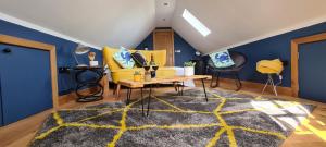 a living room with a yellow couch and a rug at The Cartshed, Coltishall, Norfolk in Norwich