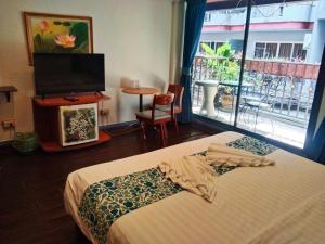 um quarto com uma cama, uma televisão e uma janela em the L Hua Hin em Hua Hin