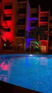 a swimming pool in front of a building at night at Les Acacias Hotel Djibouti in Djibouti